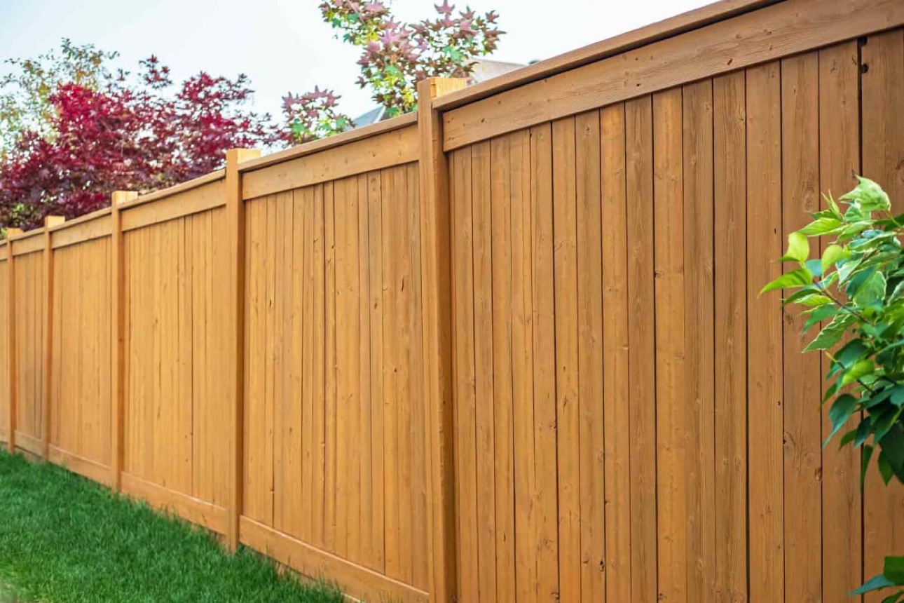 Long dark-stained wooden boundary fence